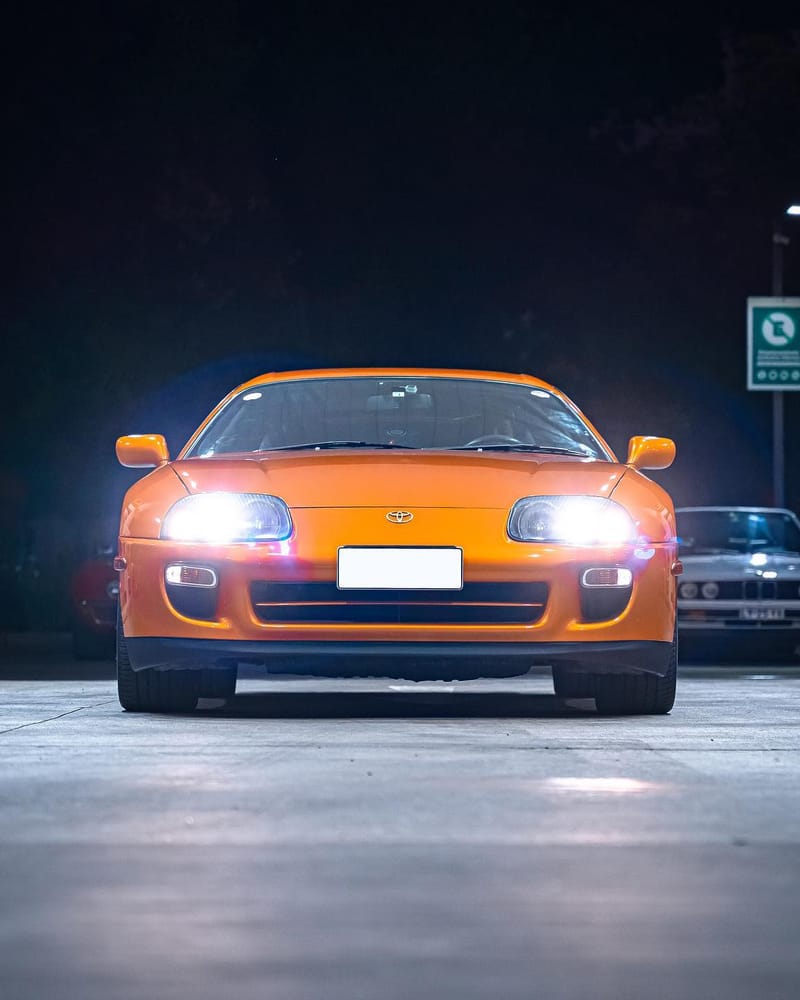 Toyota Supra MK4 wrapped in 3M Gloss Liquid Copper, front view at night