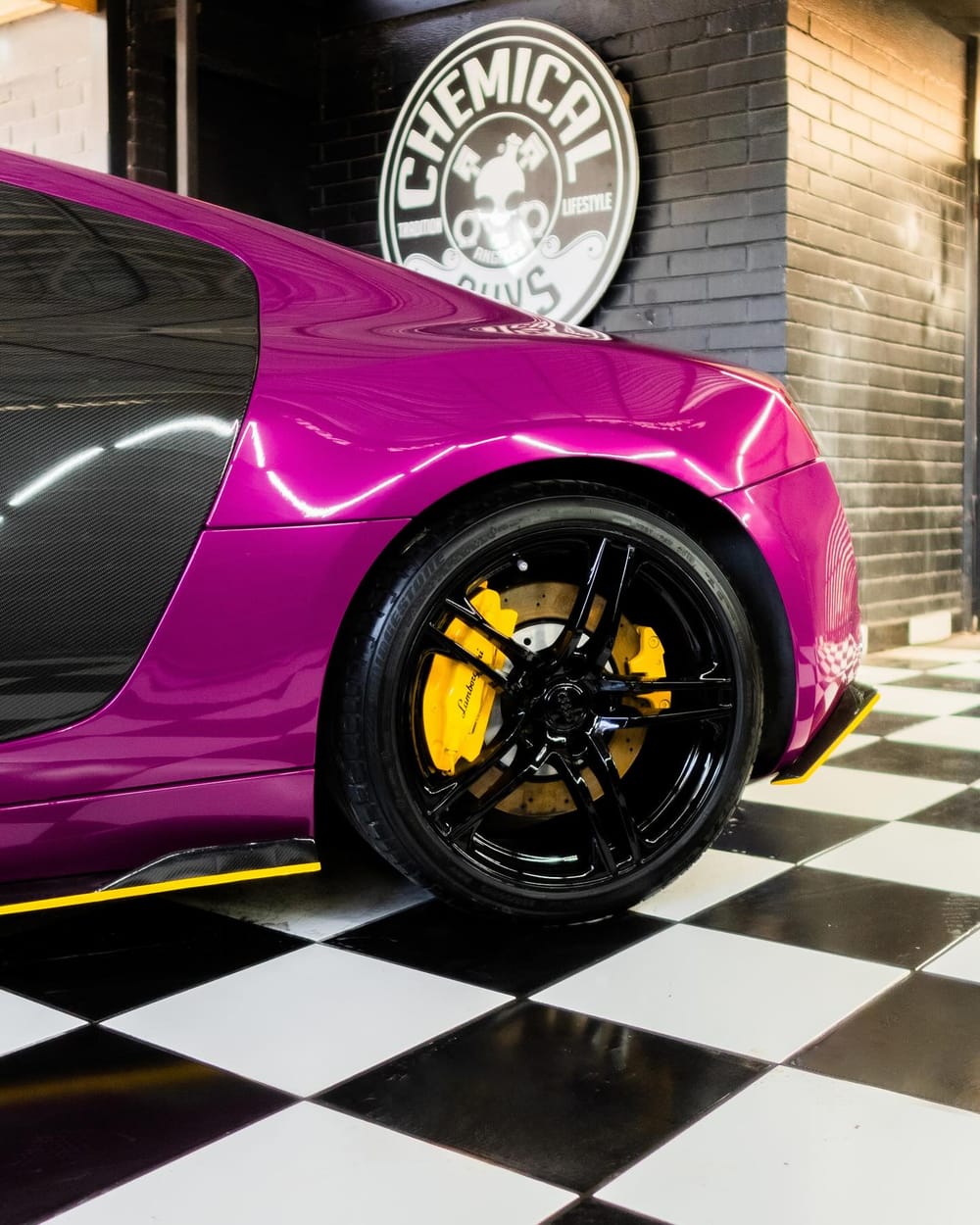Audi R8 in Berry Purple with a yellow painted brake caliper behind a black wheel